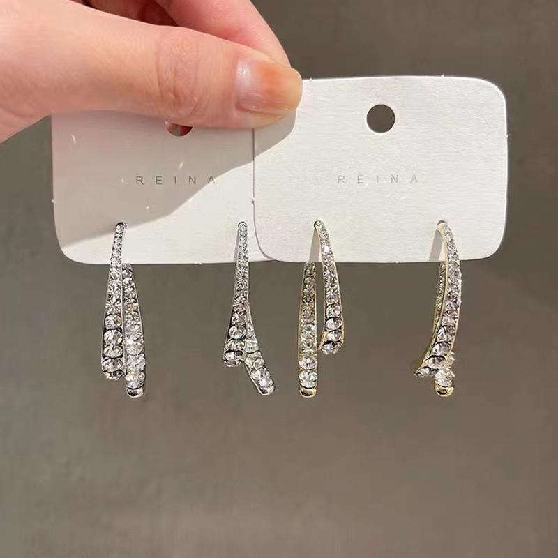 "Kryss buede øredobber i gyllen og sølv med strass, elegante for enhver anledning, allergivennlig materiale."