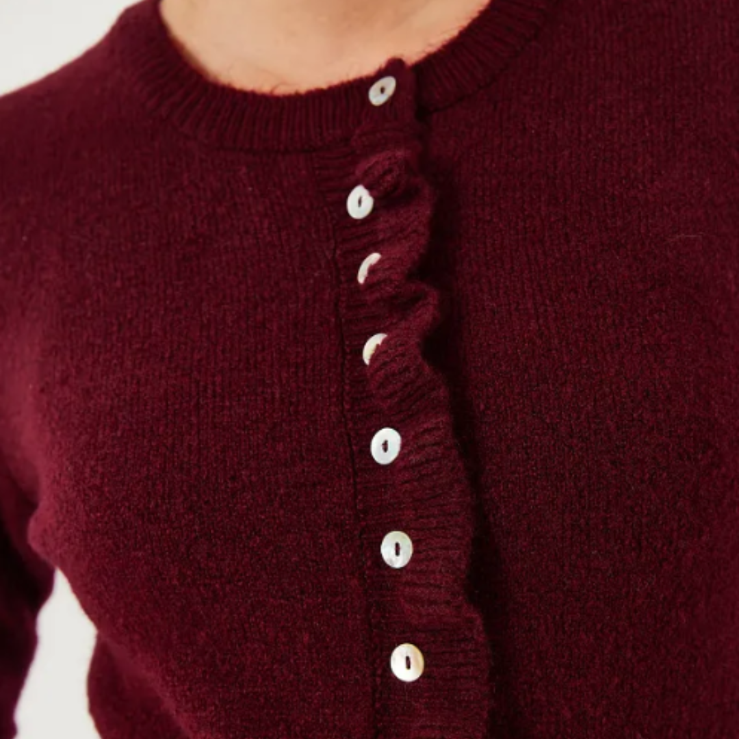 Detaljert bilde av ermet på en teksturert strikket cardigan for kvinner, highlighting kvaliteten.