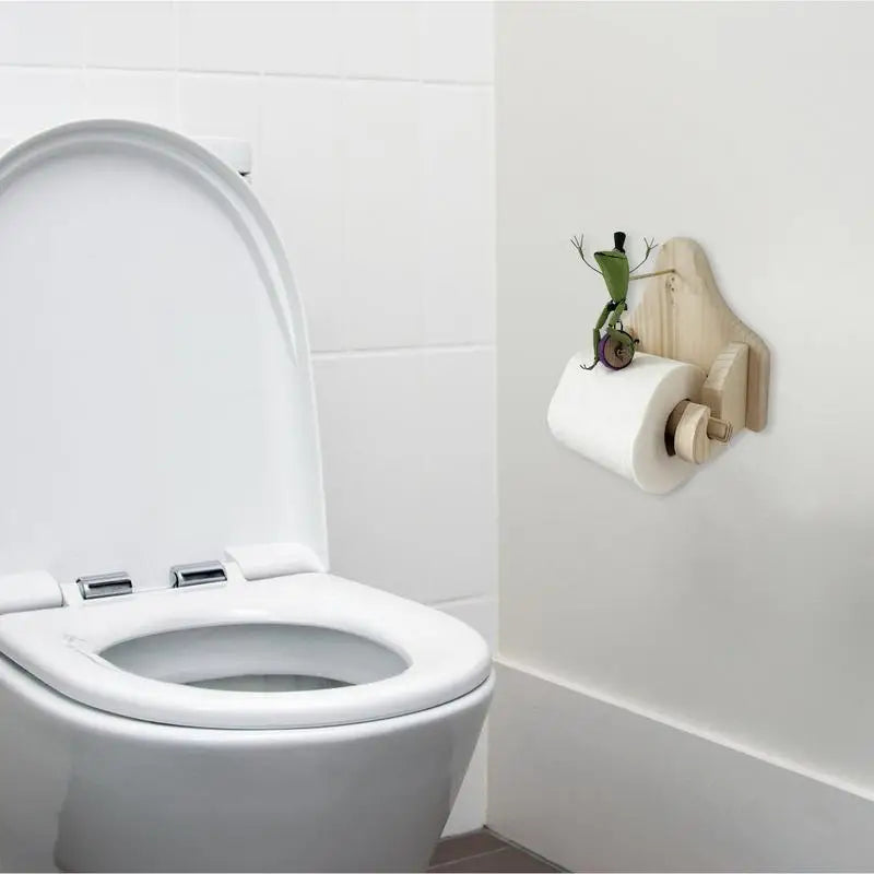 Unik toalettpapirholder i tre med frosk på sykkel-design. Et lekent og funksjonelt badetilbehør med dyremotiv.