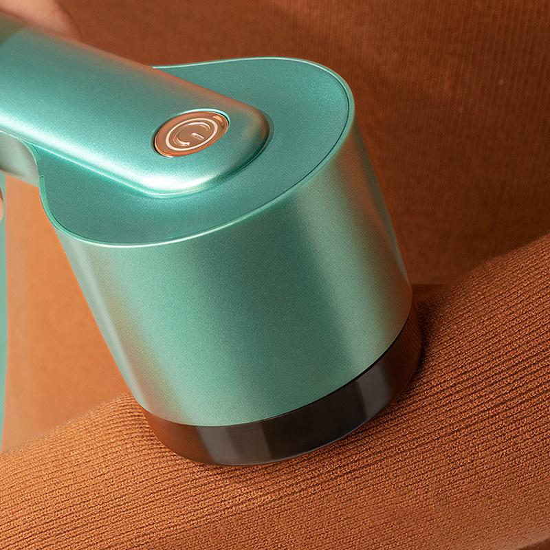 "Liten oppladbar lofjerner i grønt for skånsom stoffpleie, vises med USB-port for enkel lading og kompakt design."