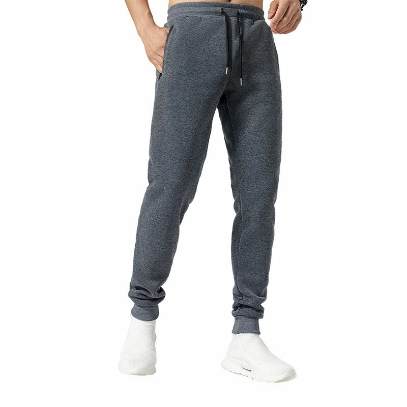 Glidelåslomme på menns sporty joggebukse, ideell for oppbevaring av småting under trening.
