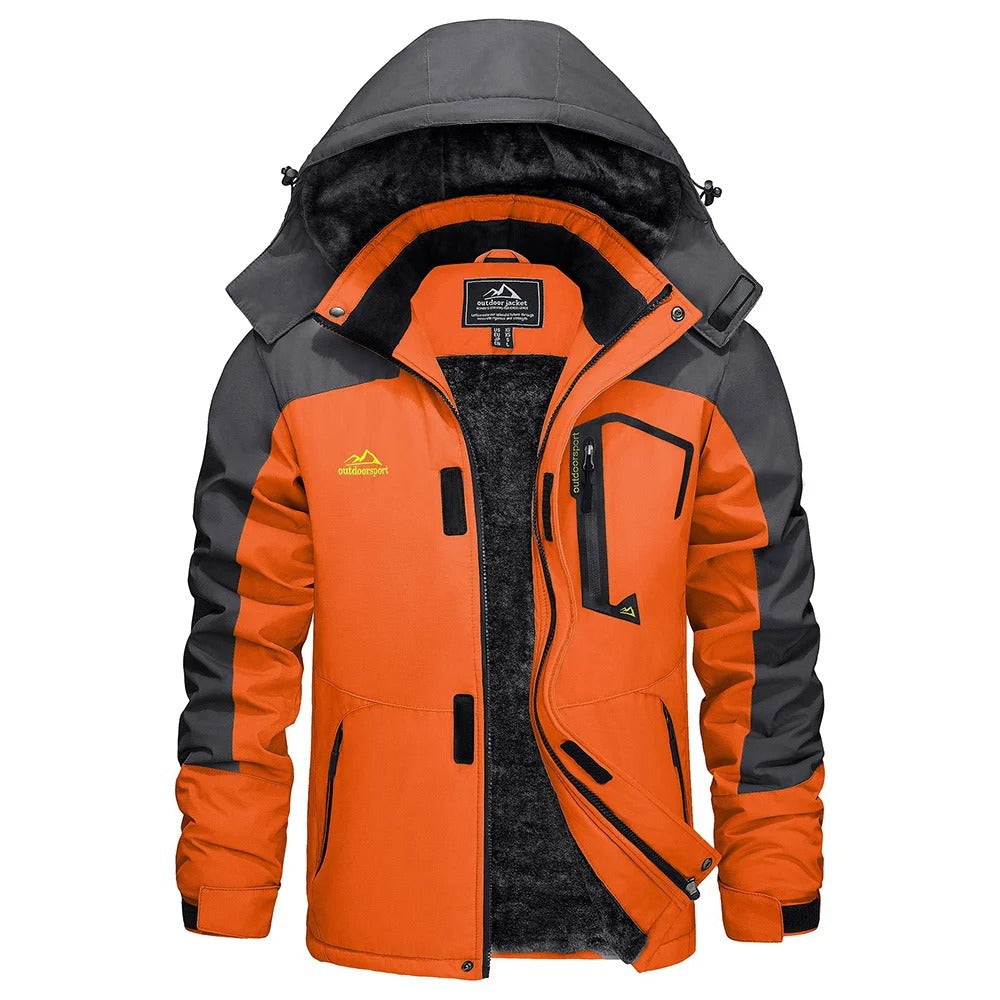 Mann utkledd i en vanntett skijakke med fleece i snødekket landskap. Vintermote.