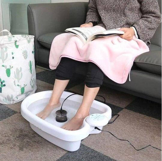 Hjemmespa: føtter i fotbad med Mini Detox Fot Spa Maskin. Fremmer helse og velvære.