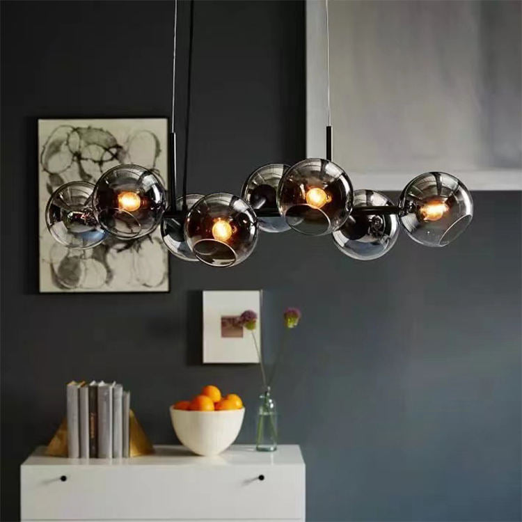 "Moderne lysekrone med nordiske røykgrå glasskuler, elegant finish for luksuriøst interiør, gir innbydende lys."