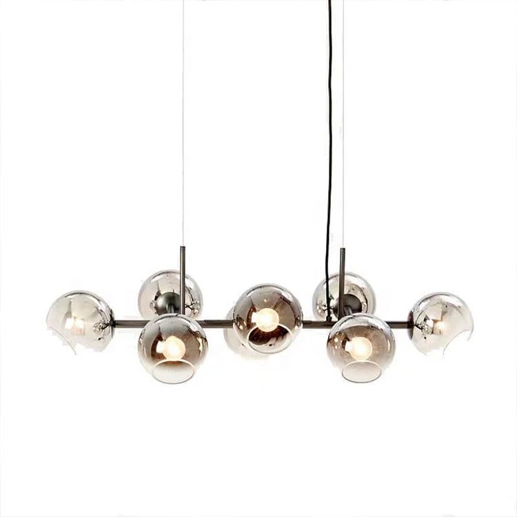"Moderne lysekrone med nordiske røykgrå glasskuler, elegant finish for luksuriøst interiør, gir innbydende lys."