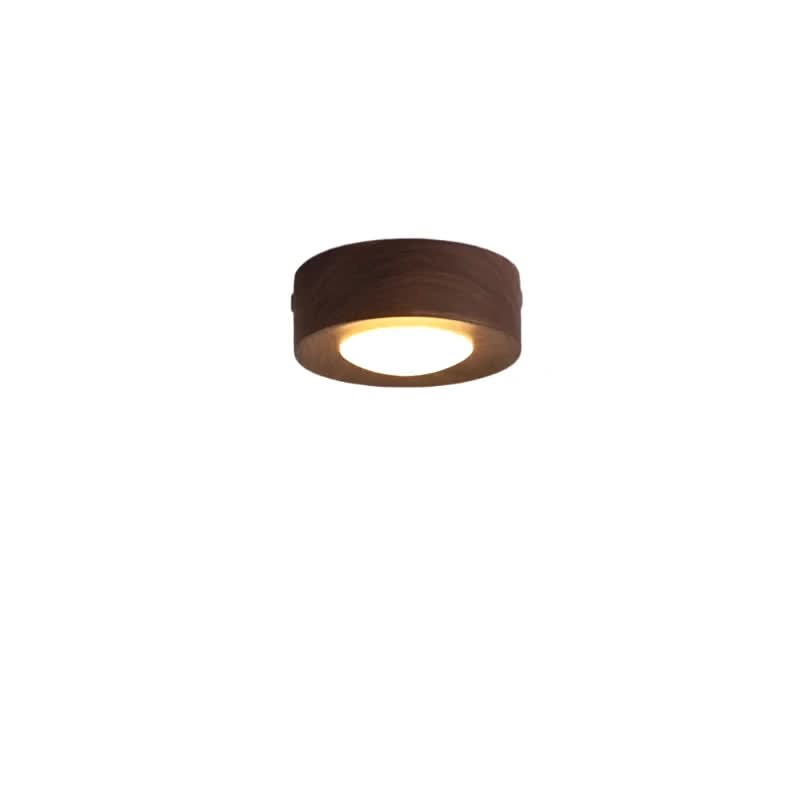 Detaljbilde av LED-taklampens valnøttfargede finish og den varme lyskjeglen.