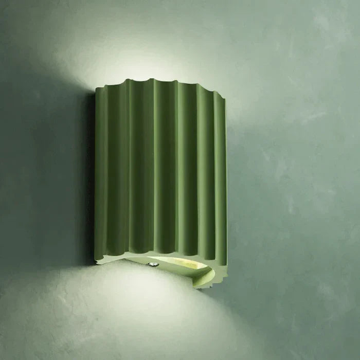 Montert vegglampe i kunstnerisk design, gir subtil belysning i gang eller stue.