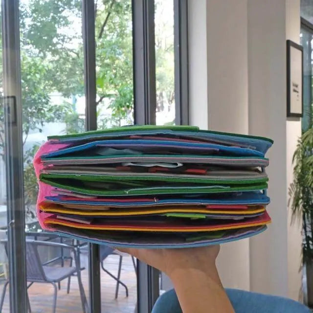 Barn i ferd med å leke med en blå Montessori aktivitetsbok, utvikler finmotorikk og læring
