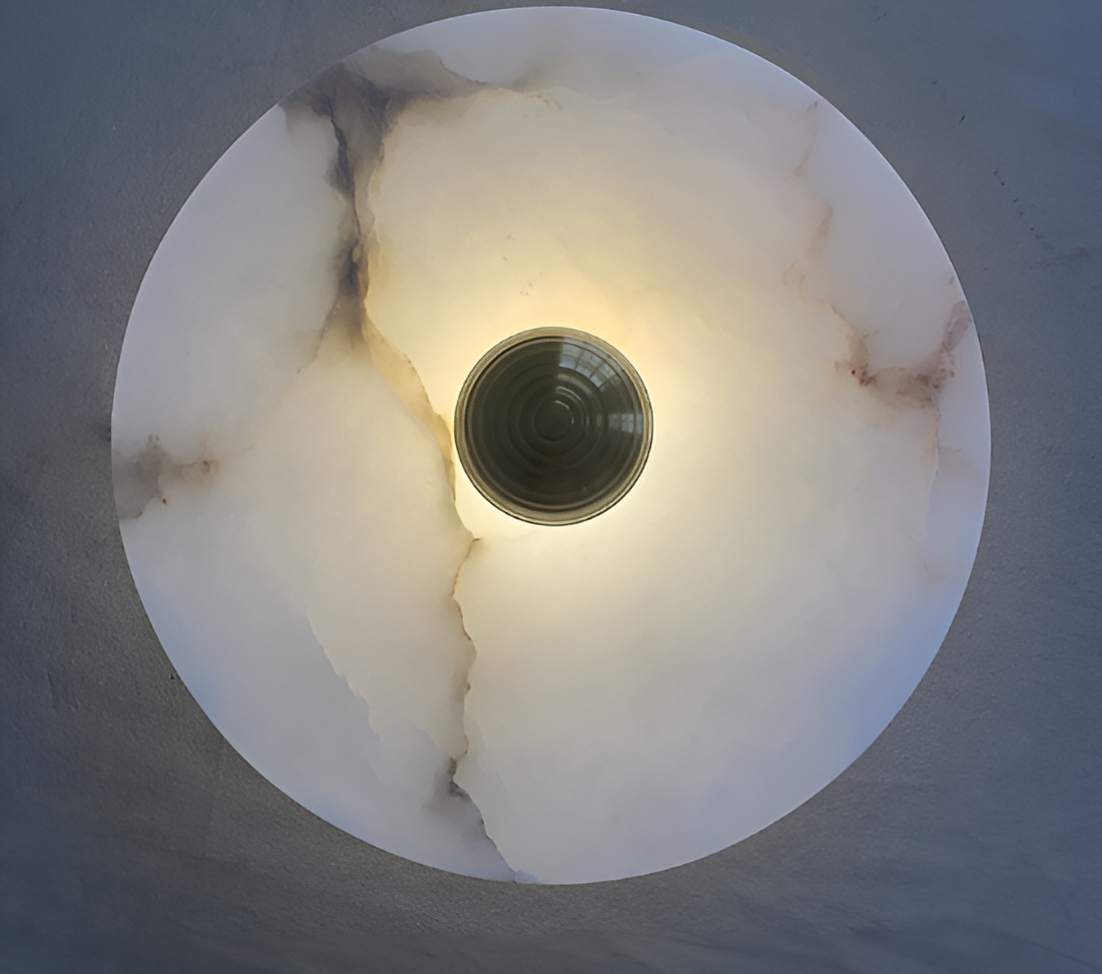 Oval alabaster bordlampe med messingfot, gir varm glød og elegant preg i moderne interiør. Perfekt for stue og soverom.