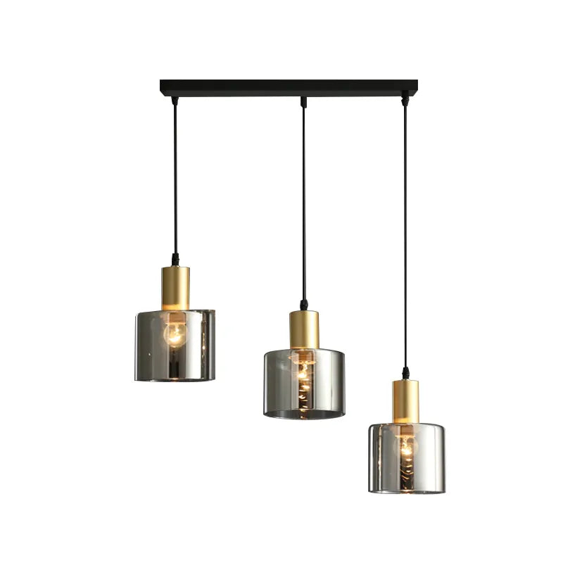 "Pendellampe i svart med gylne detaljer, røykfarget glass; justerbart lys for moderne stil og luksuriøs atmosfære."
