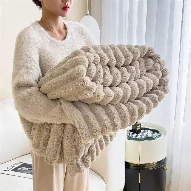 Plysj og mykt teppe for sofa eller seng, skaper en koselig atmosfære.