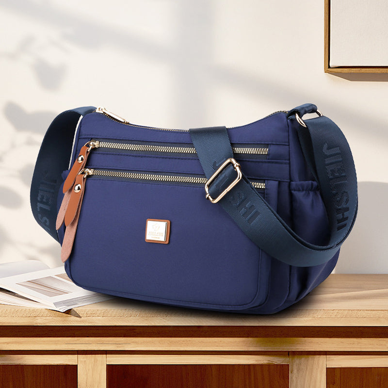 Praktisk skulderveske med flere rom i lett, slitesterkt nylon, ideell for daglig bruk og reiser, i elegant design.