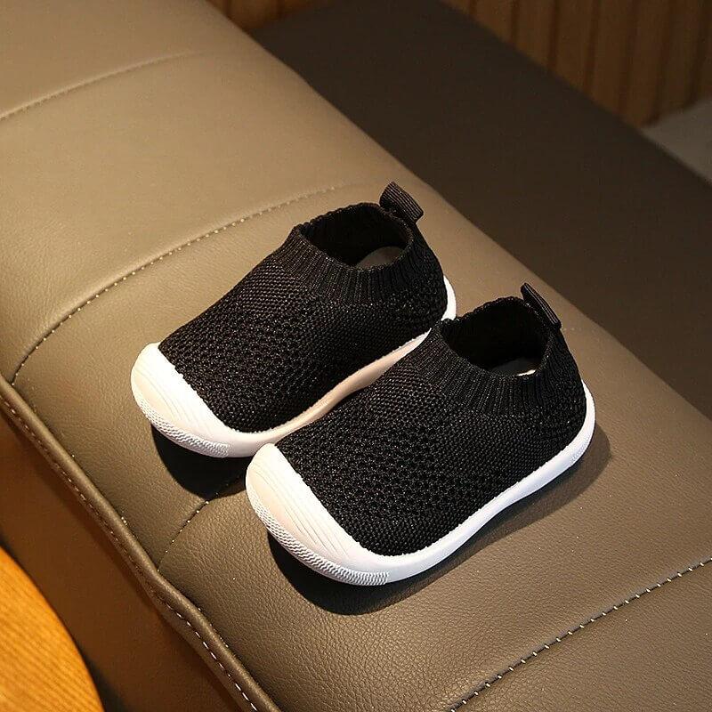 Grå babysko med pustende materiale og sklisikker såle, utmerket for komfortable første skritt.
