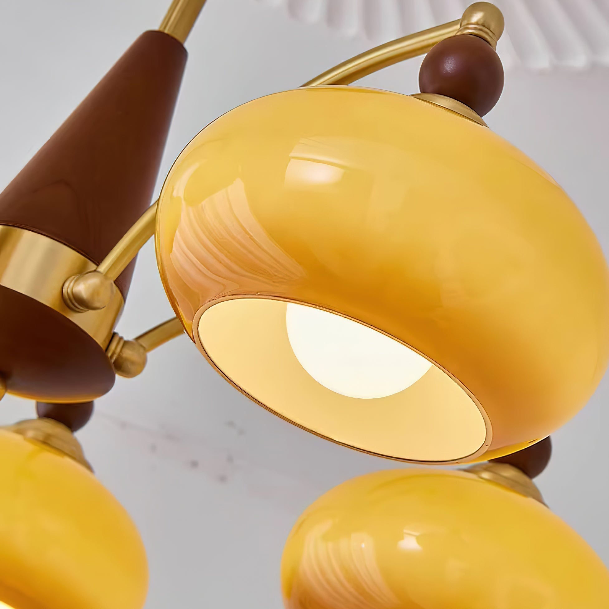 "Retro lysekrone med gyllengule skjermer og klassisk design, laget av tre og messing, gir varmt lys til spisestue."