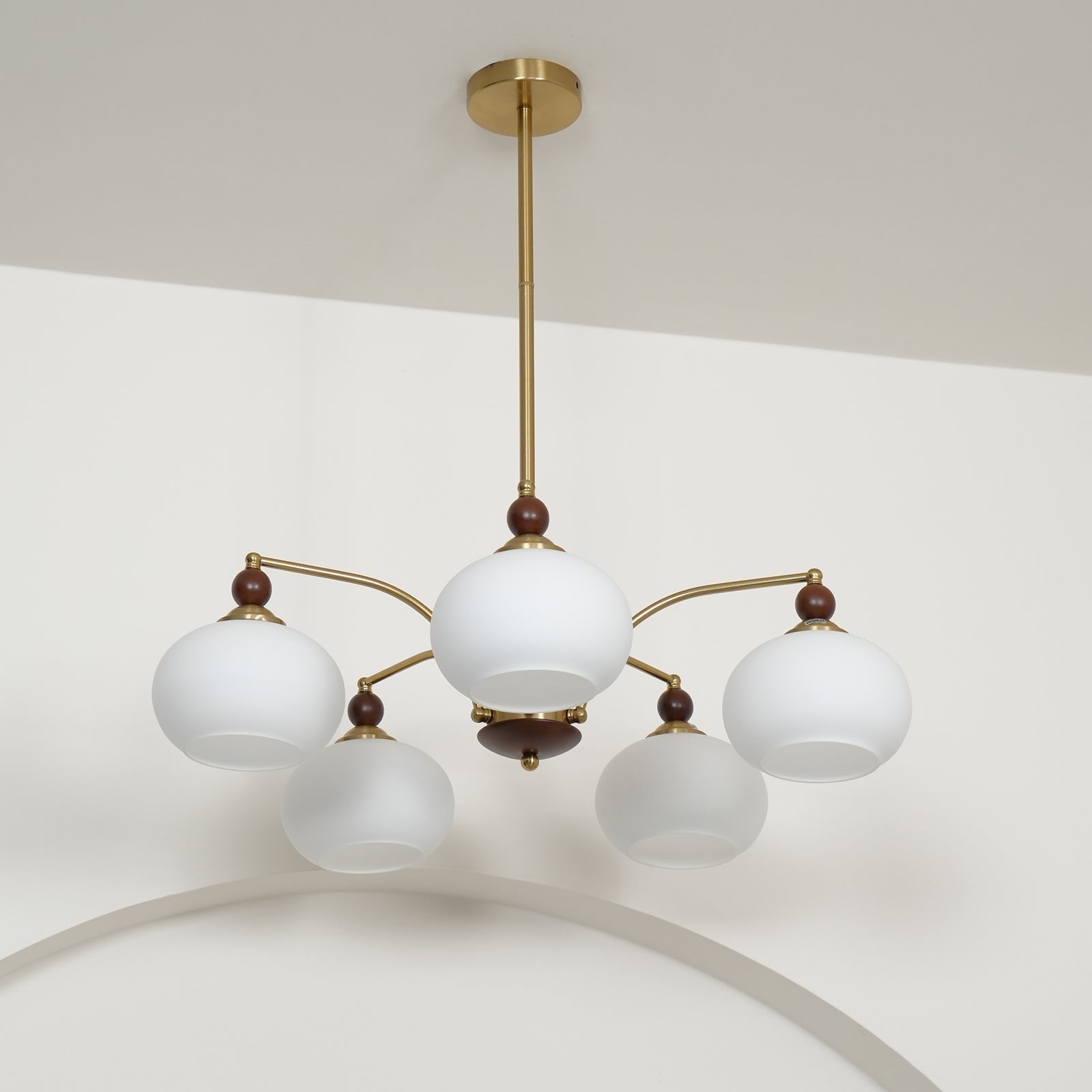 "Retro lysekrone med gyllengule skjermer og klassisk design, laget av tre og messing, gir varmt lys til spisestue."