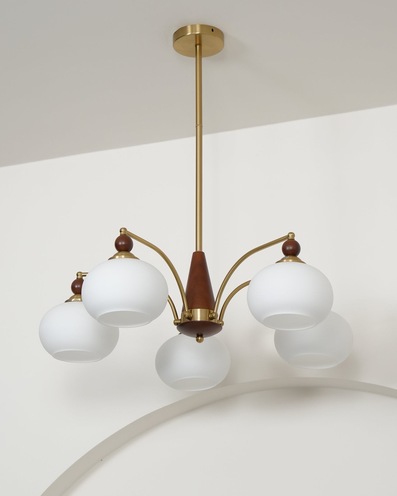 "Retro lysekrone med gyllengule skjermer og klassisk design, laget av tre og messing, gir varmt lys til spisestue."