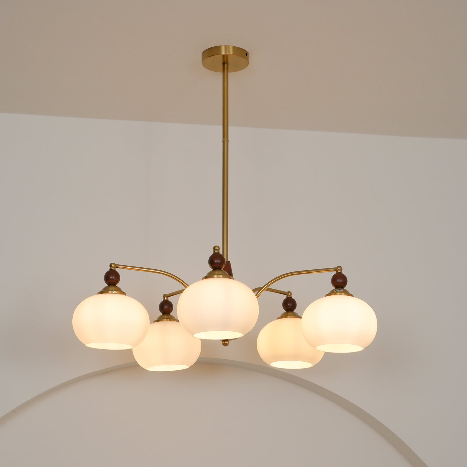 "Retro lysekrone med gyllengule skjermer og klassisk design, laget av tre og messing, gir varmt lys til spisestue."