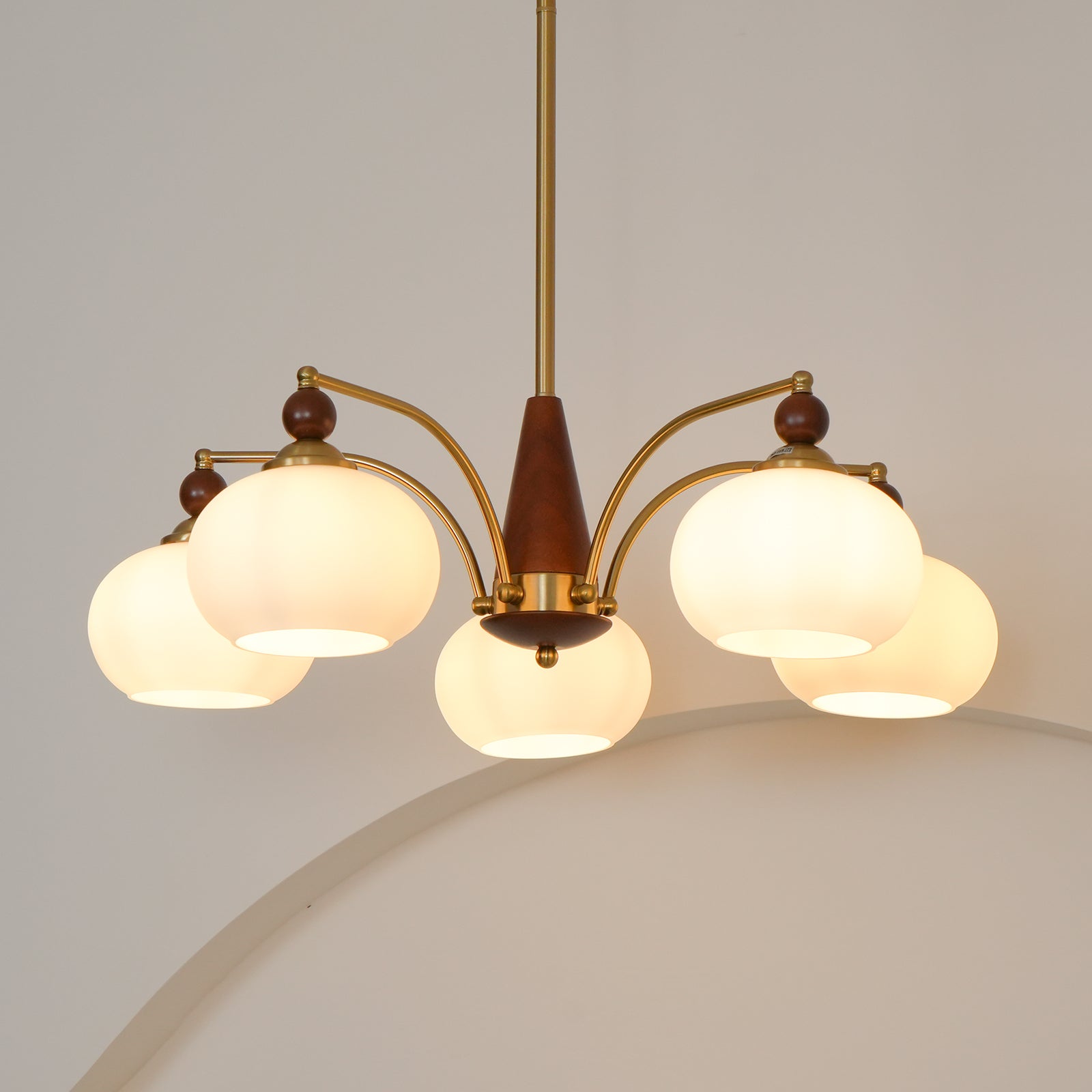 "Retro lysekrone med gyllengule skjermer og klassisk design, laget av tre og messing, gir varmt lys til spisestue."