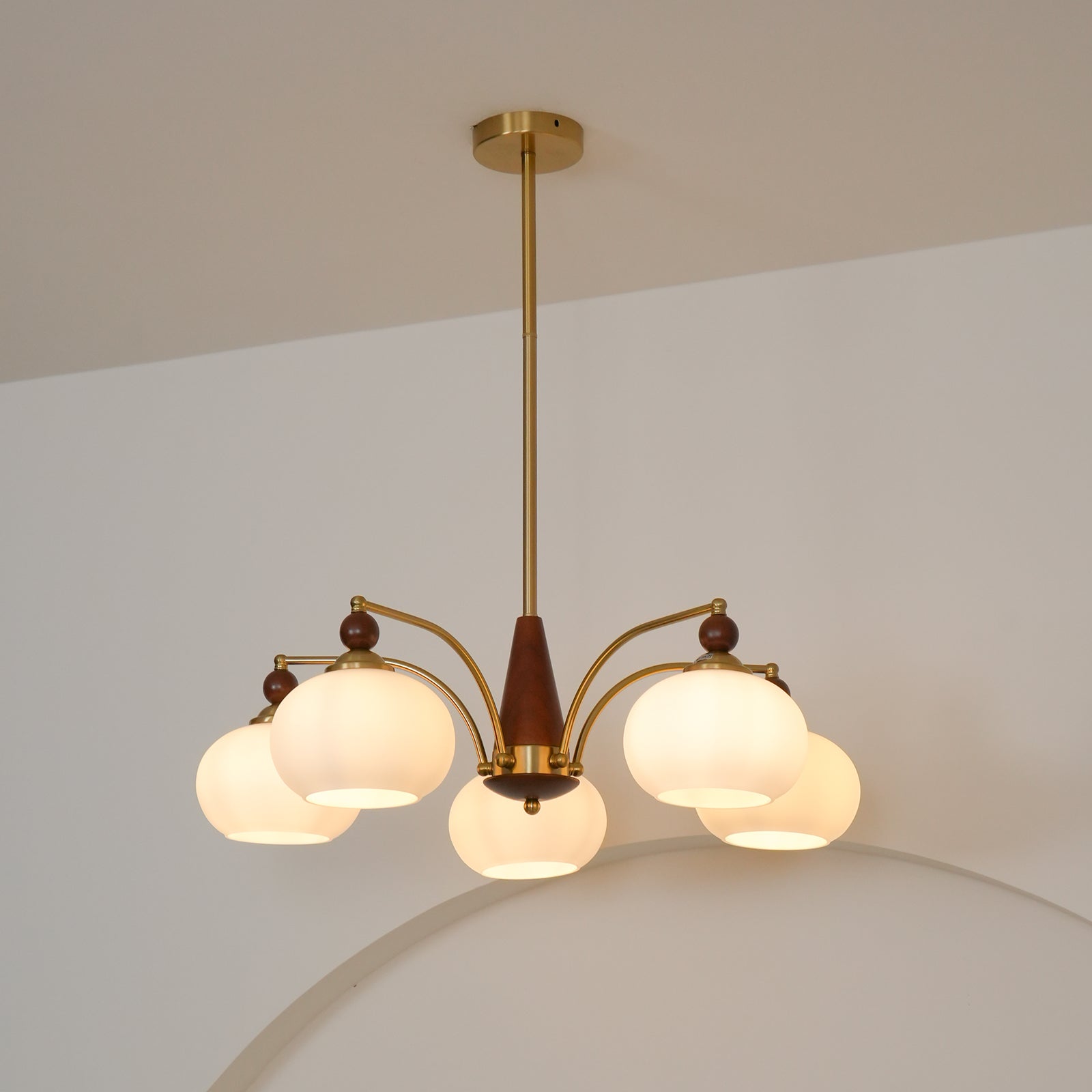 "Retro lysekrone med gyllengule skjermer og klassisk design, laget av tre og messing, gir varmt lys til spisestue."