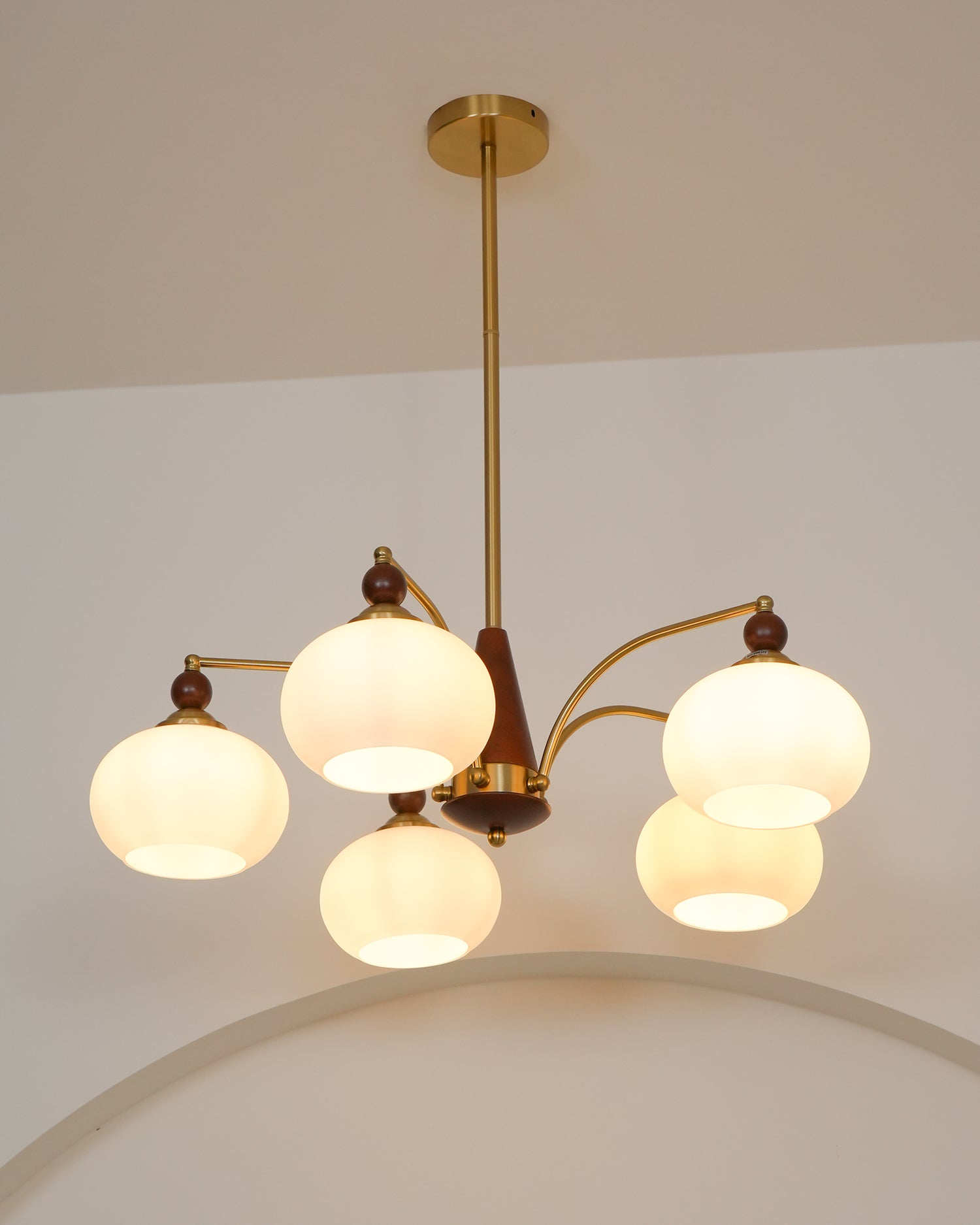 "Retro lysekrone med gyllengule skjermer og klassisk design, laget av tre og messing, gir varmt lys til spisestue."