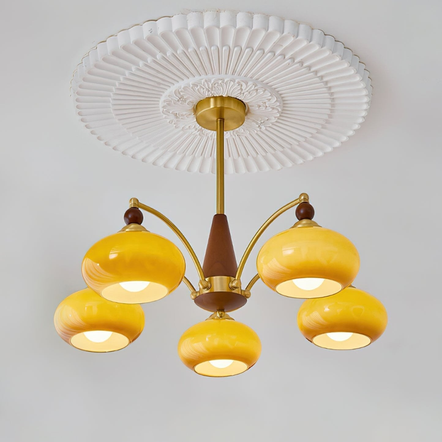 "Retro lysekrone med gyllengule skjermer og klassisk design, laget av tre og messing, gir varmt lys til spisestue."