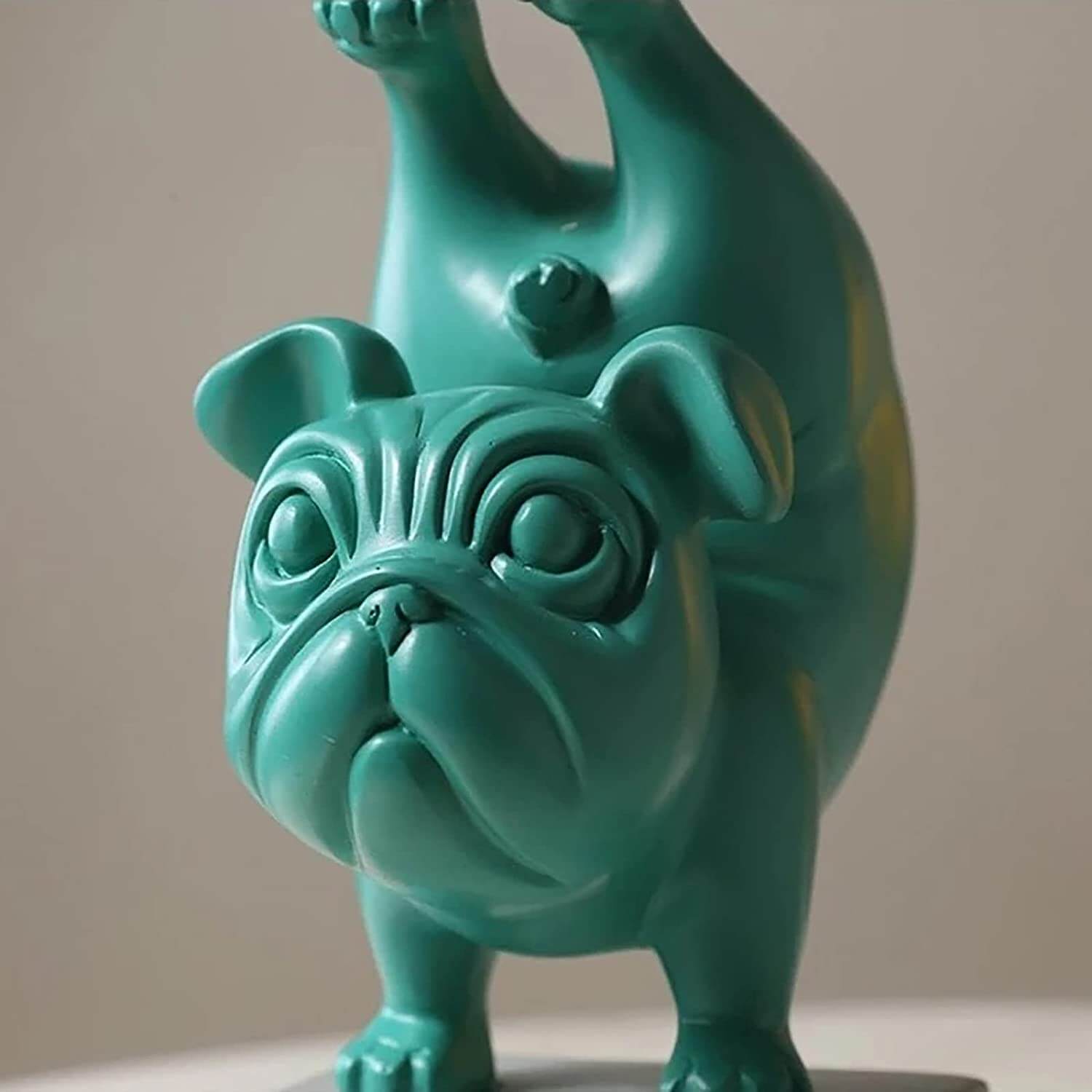Minnesmerke eller leketøy: liten bulldog-figur i yogapositur, laget for dekorasjon.