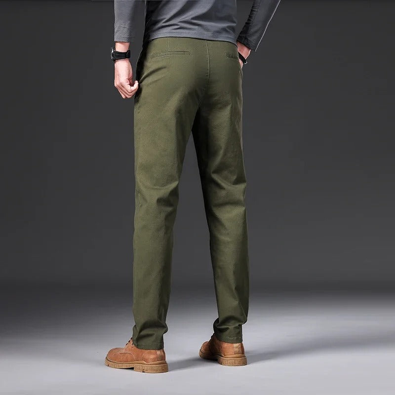 En mann poserer i slim fit bukser med elastisk midje, utstråler komfort og moderne stil.