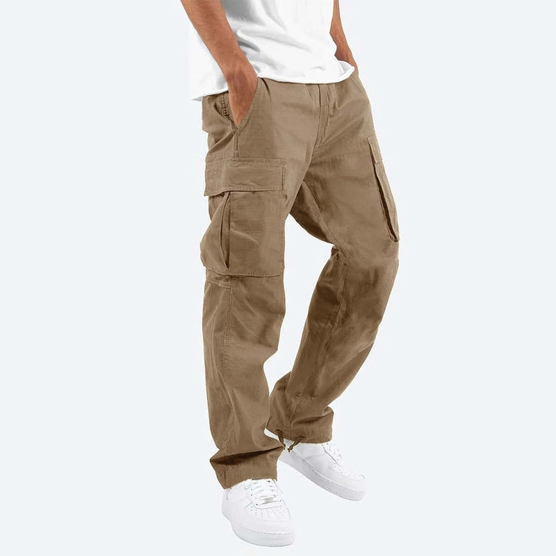 Ung mann iført sorte slim fit cargo bukser i bomullsblanding, kombinert med fritidsgenser ute.
