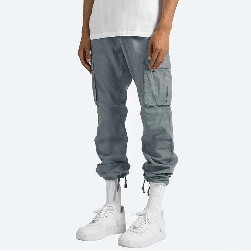 Mann med herre cargo bukser, slim fit i bomullsmiks, i aktiv positur, viser bevegelsesfrihet.