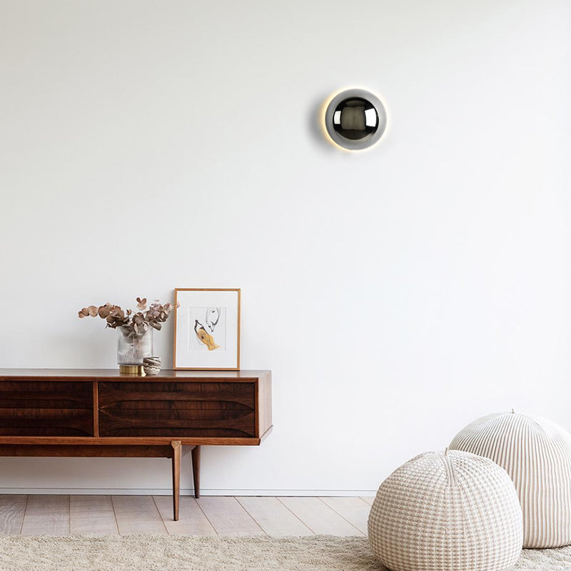 "Stilfull vegglampe med rund silhuett, gull finish og solformørkelseseffekt. Perfekt for moderne og middelalderlig interiør."