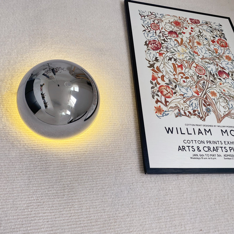 "Stilfull vegglampe med rund silhuett, gull finish og solformørkelseseffekt. Perfekt for moderne og middelalderlig interiør."