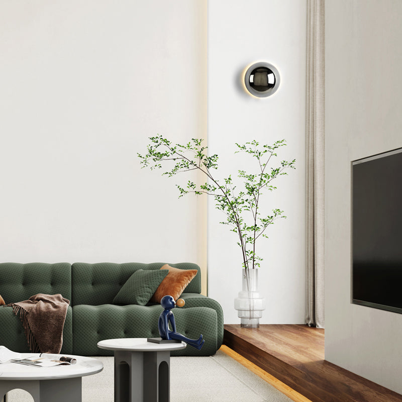 "Stilfull vegglampe med rund silhuett, gull finish og solformørkelseseffekt. Perfekt for moderne og middelalderlig interiør."