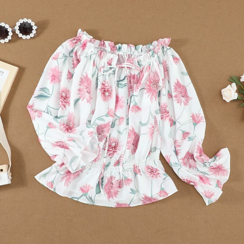 Stilig off-shoulder damebluse med blomstermønster, volanger. Elegant og trendy kvinneklær.