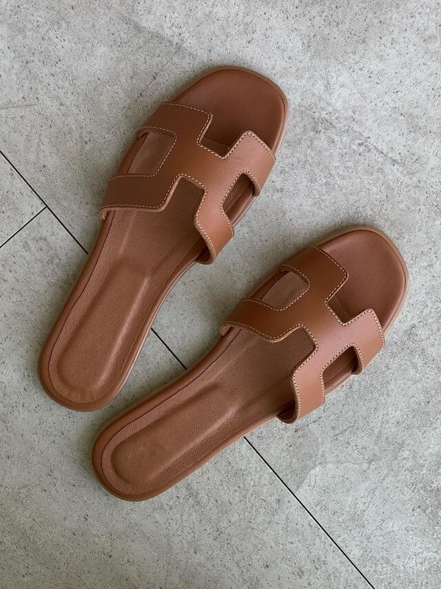 Stilige kvinnesandaler med brede remmer og geometriske utskjæringer, perfekt for en moderne og komfortabel look.