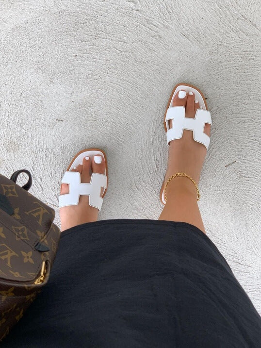 Stilige kvinnesandaler med brede remmer og geometriske utskjæringer, perfekt for en moderne og komfortabel look.