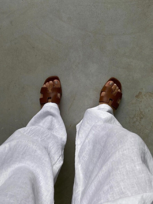 Stilige kvinnesandaler med brede remmer og geometriske utskjæringer, perfekt for en moderne og komfortabel look.