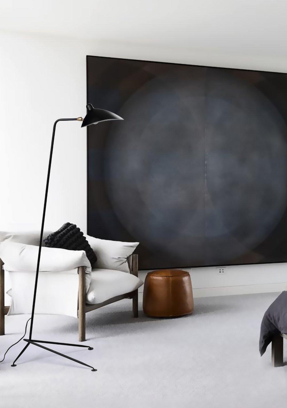 "Stilren svart gulvlampe med skulpturelle linjer og tre justerbare armer, ideell for moderne interiørdesign."