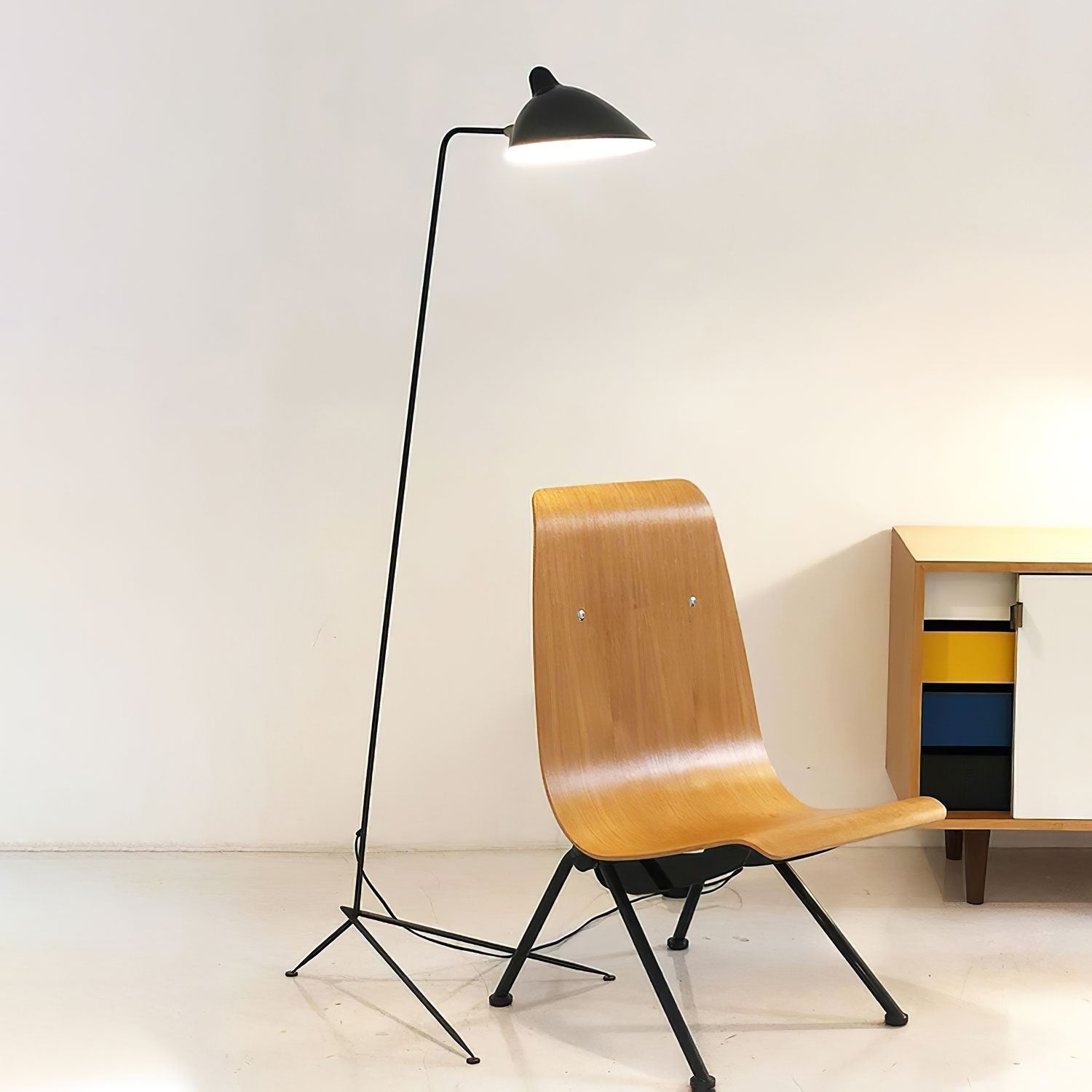 "Stilren svart gulvlampe med skulpturelle linjer og tre justerbare armer, ideell for moderne interiørdesign."