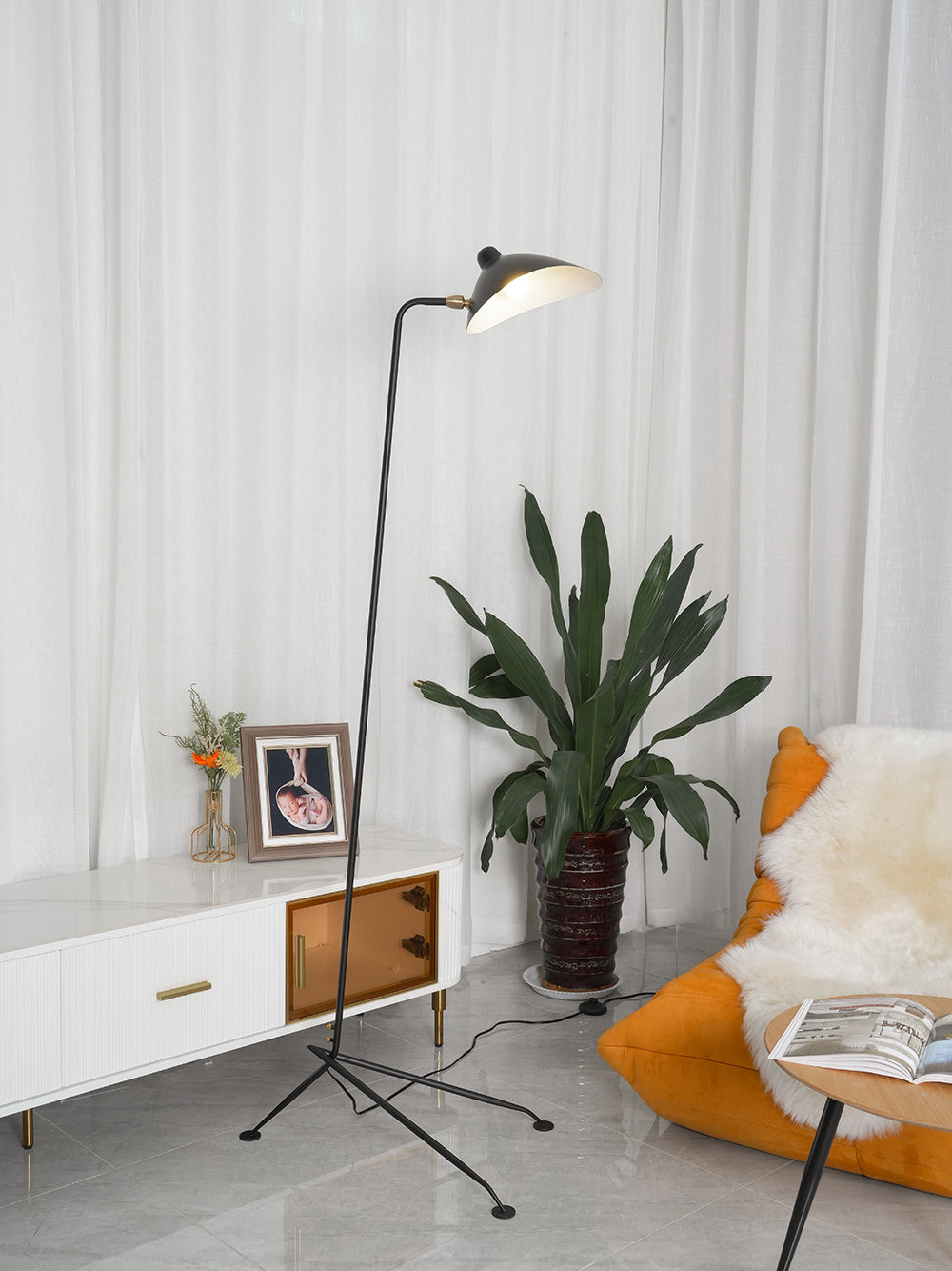 "Stilren svart gulvlampe med skulpturelle linjer og tre justerbare armer, ideell for moderne interiørdesign."