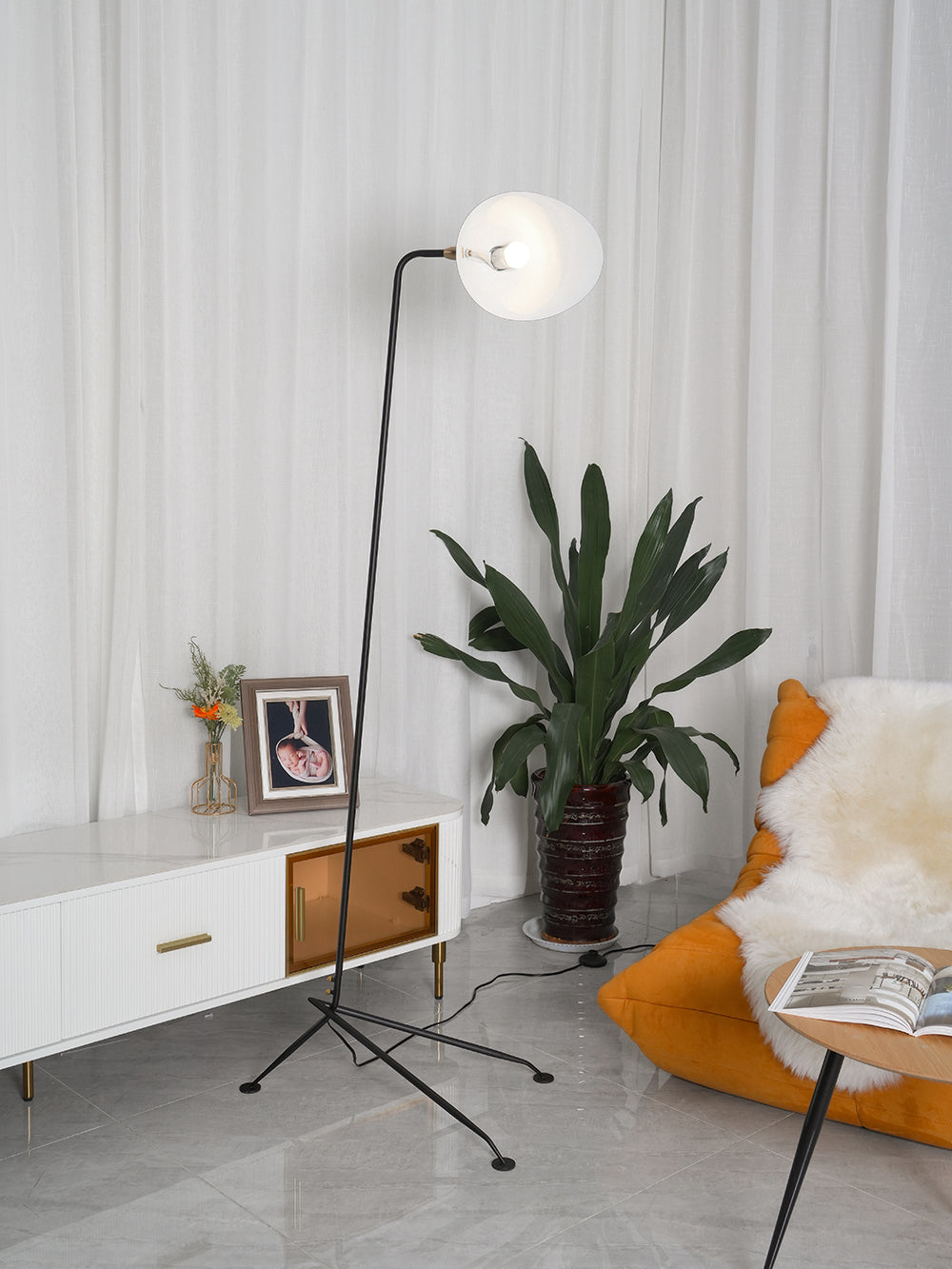 "Stilren svart gulvlampe med skulpturelle linjer og tre justerbare armer, ideell for moderne interiørdesign."