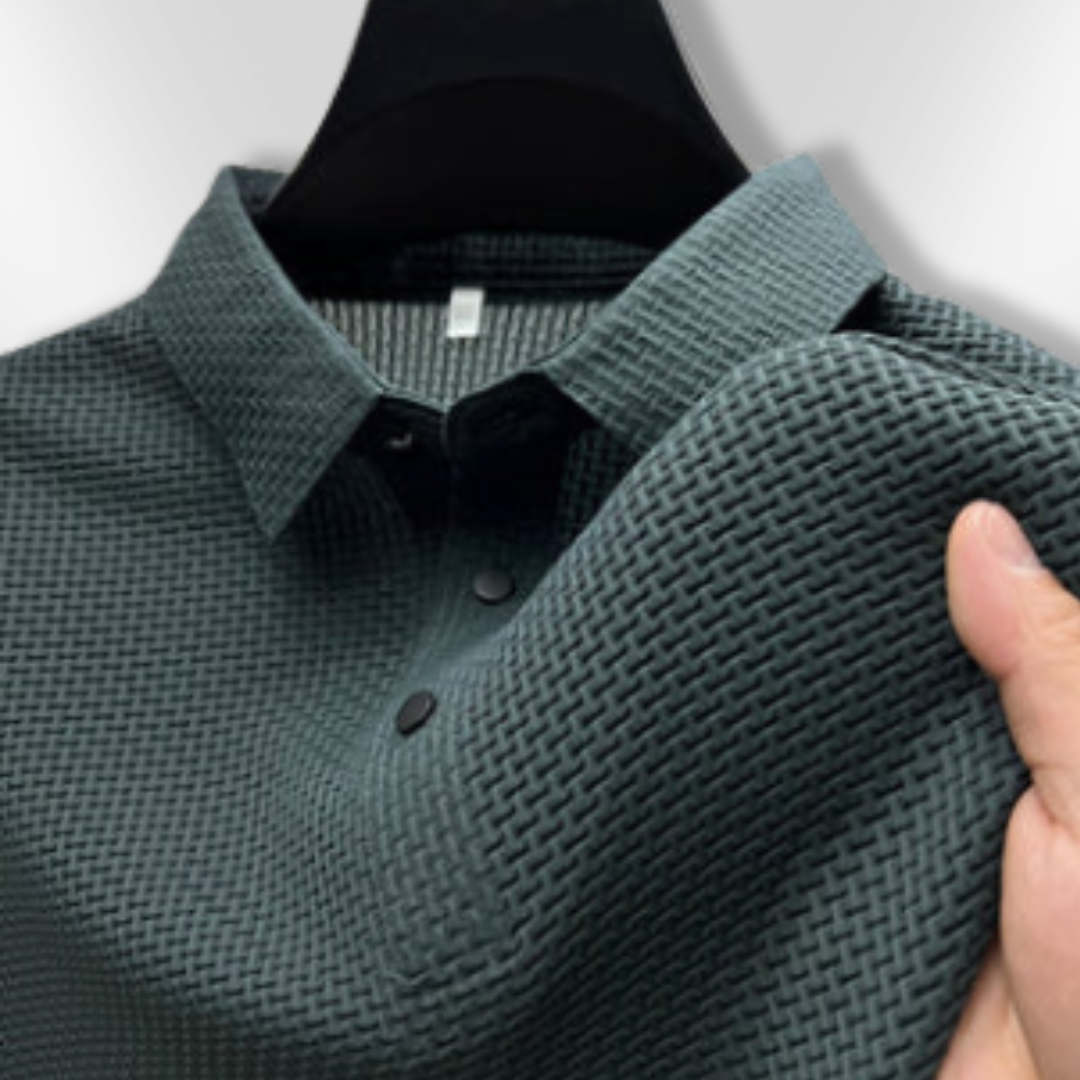 Nærbilde av det strukturerte stoffet på en elegant herre polo, fremhever kvaliteten.