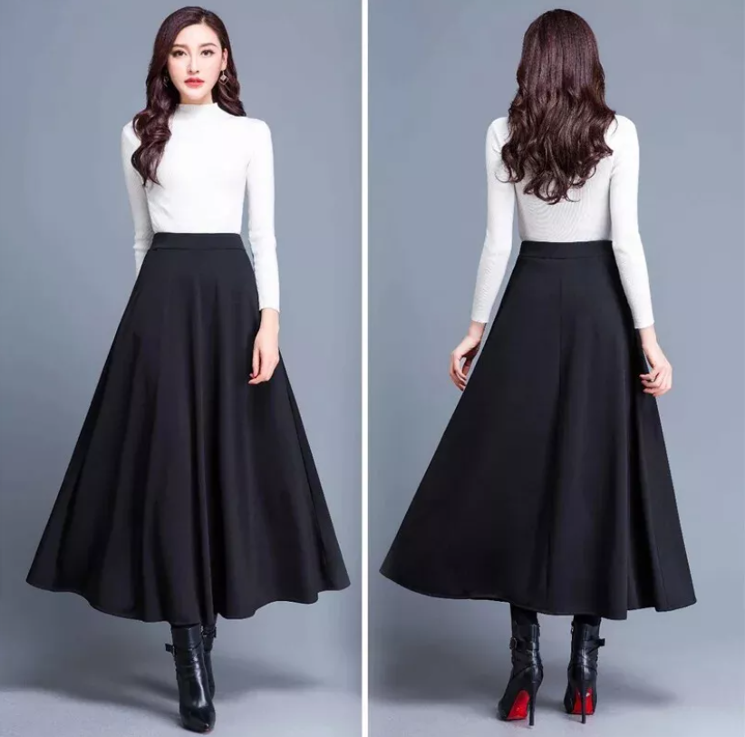 Dame modell bærer svart plissert A-linje skjørt med høy midje, elegant stil.