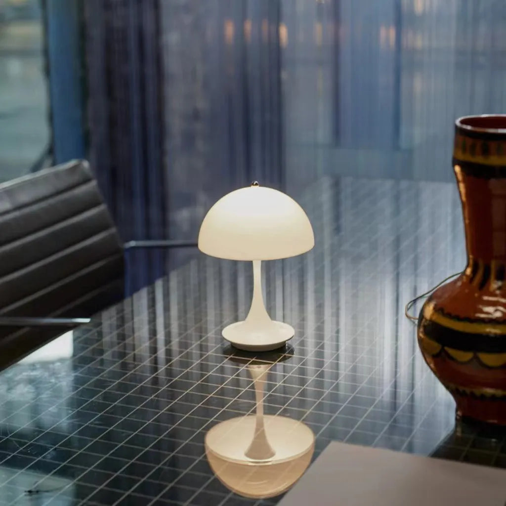 "Trådløs bordlampe med justerbar lysstyrke og elegant design, laget av metall og glass, tilgjengelig i hvit og oransje."