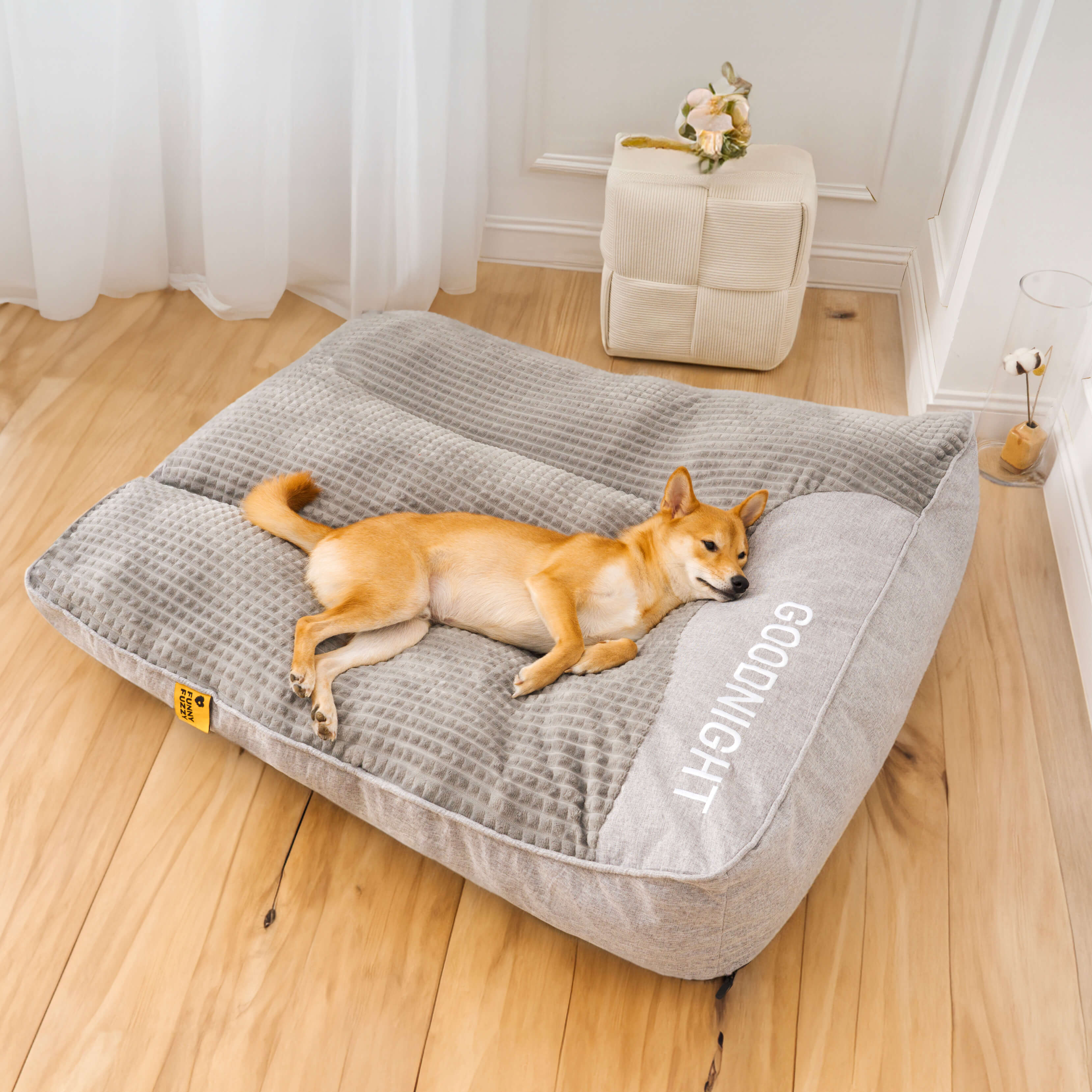 "Tykk ripebeskyttende hundeseng, myk, slitesterk med ryggstøtte, beige farge, i rom med stilfull innredning."