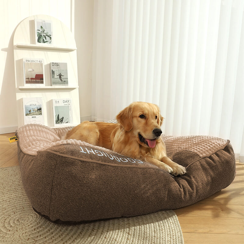 "Tykk ripebeskyttende hundeseng, myk, slitesterk med ryggstøtte, beige farge, i rom med stilfull innredning."