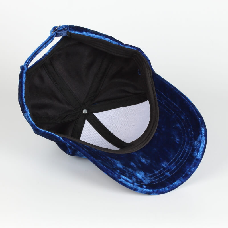 Nærbilde av fløyelsstoffet på en baseballcaps, farge varierer per bilde
