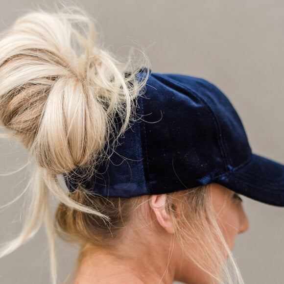 Modell iført en hvit fløyels baseballcaps, viser fritidsstil