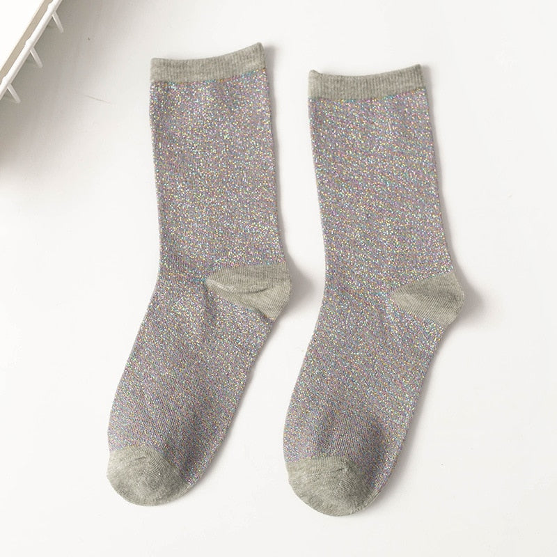 Fire par komfortable unisex glittersokker i ulike farger, arrangert over hverandre.