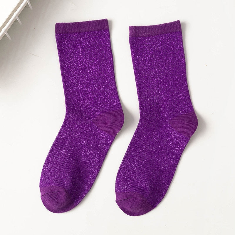 Svart bakgrunn som fremhever fargerike og glitrende unisex sokker for menn, ensfarget variant.
