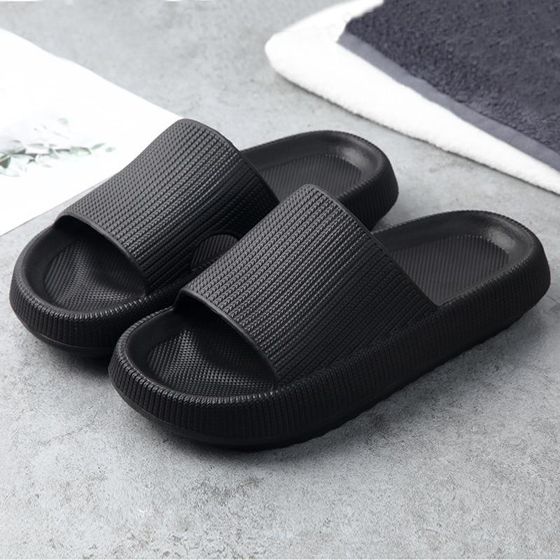 Sideprofil av en svart unisex sandal, fremhever den tykke, komfortable sålen og hurtigtørkende materialer.